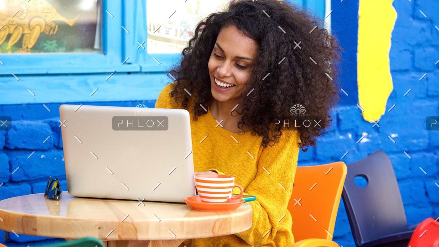 demo-attachment-65-happy-young-woman-sitting-at-outdoor-cafe-using-PFFBJ93